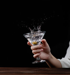 girl holding a Martini glass from which fly spray