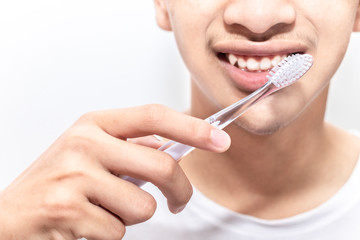 Young man with toothbrush cleaning teeth in the bathroom. Close up a man brushing his teeth. health care and dental hygiene concept.