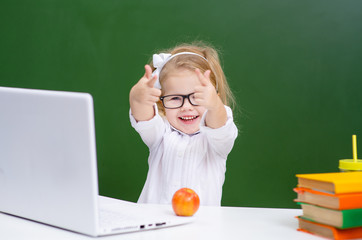 the child is learning sitting at the computer in front of the school Board