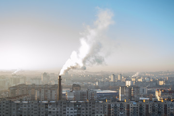 Smoking chimney of a thermal power plant on the background of a morning city