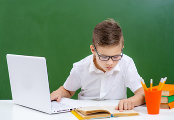 Small cute boy work on laptop device