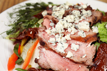 Delicious salad with roasted meat and vegetables on plate, closeup