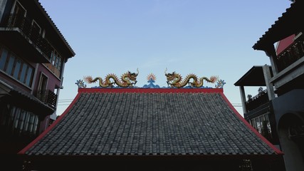 roof clay tiles with the Dragon statue in Chinese Temple and clear blue sky.
