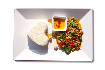 Stir fried basil leaf pork with rice on a white background.