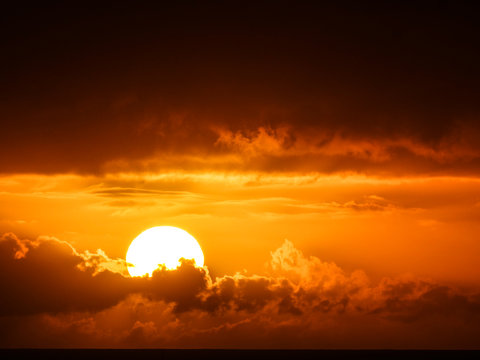 sun behind dark clouds