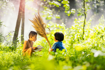 Asian students reading letter in a forest. The boys and girls are talking about the letters and exam results of the school in the countryside. Kids go back to school.