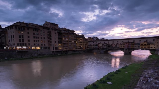 Sunset view of famous Ponte Vecchio over Arno River in Florence, Italy, timelapse day to night. Close up.