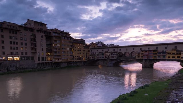 Sunset view of famous Ponte Vecchio over Arno River in Florence, Italy, timelapse day to night. Close up.