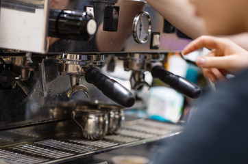 a Barista makes the coffee in the coffee machine