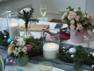 beautifully decorated festive table with bouquets of flowers, burning candles and champagne