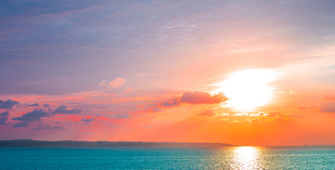 bright multi-colored sky and sun over the sea at dawn, panorama