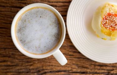 Hot coffee and spring roll on wooden table in the morning.