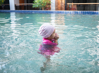 Naklejka premium Happy Asian family enjoying summer vacation in swimming pool at resort.