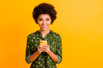 Portrait of positive cheerful afro american girl social network addicted user hold smartphone read...