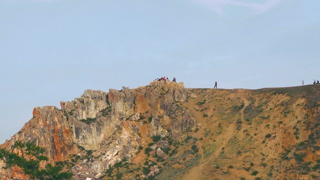Tourists walk on Cape Burkhan on the island of Olkhon on lake Baikal