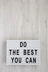 'Do the best you can' words on a lightbox on a white wooden background, top view. Overhead, from above, flat lay. Copy space.