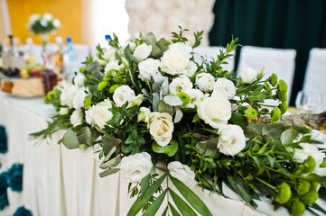 Beautiful wedding set decoration in the restaurant. Flowers on table of newlywed.