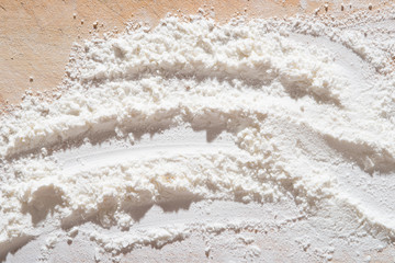 White flour heap on wooden board from top view. 