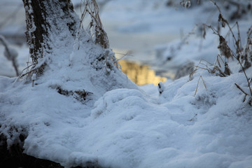 Winter snow  and blurred stream reflects the setting sun behind