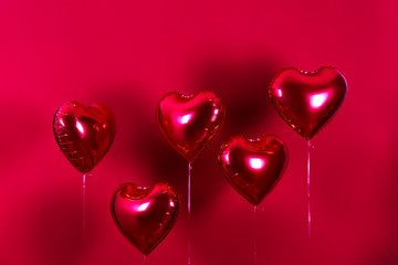 Celebrating Saint Valentine's Day with heart shaped red foil air balloon. Gift for loved woman on...