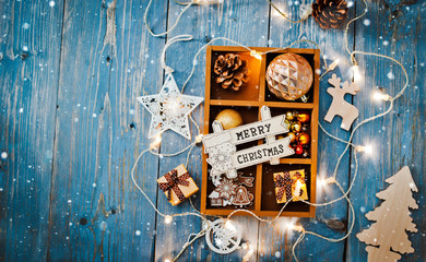 Christmas decorations are in a box on a blue wooden background.