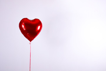 Celebrating Saint Valentine's Day with heart shaped red foil air balloon. Gift for loved woman on...