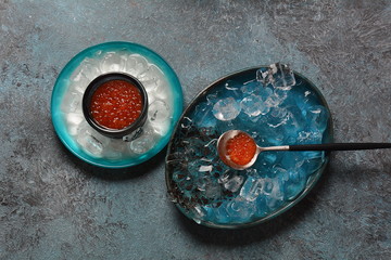 Delicious red caviar in a bowl with ice cubes