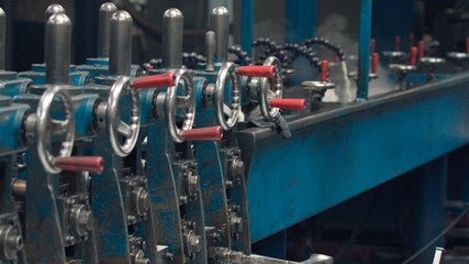 Steel cog gear set of metal sheet bending machine in a metalwork factory.