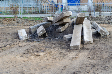 A pile of concrete blocks on the ground. Old curbs and stones on the ground. Preparation for the...