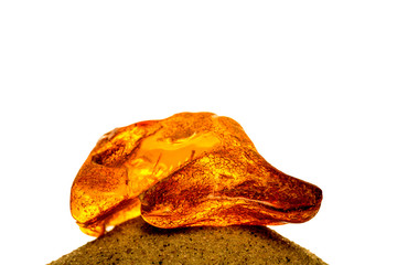 Amber in sun with inclusions on a white empty background