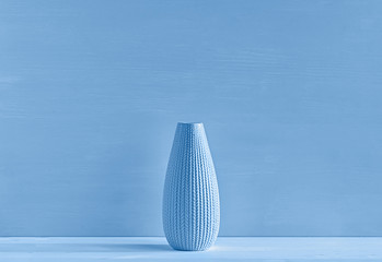 Ceramic vase on a blue background. The concept of minimalism. Close-up.