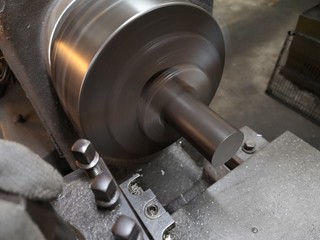 product clamped in a rotating chuck of the machine in background.