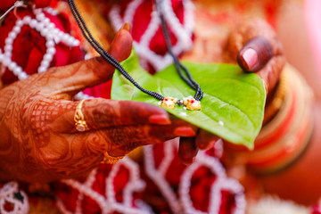 Traditional indian wedding ceremony : Mangalsutra with green leaf holding in hand 