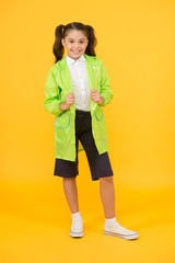 Happy schoolgirl wear raincoat. Invest in durable kids rainwear to keep children out in fresh air....