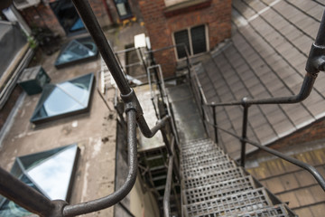 urban new york  style metal vintage steel fire escape ladder stairs in manchester england. Fire escape route on the side of a building saves lives.