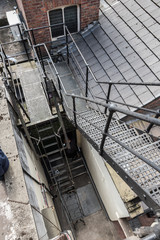Obraz premium urban new york style metal vintage steel fire escape ladder stairs in manchester england. Fire escape route on the side of a building saves lives.