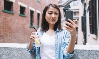 Happy Asian female tourist taking selfie and smiling