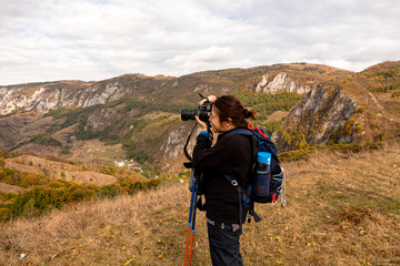 Woman tourist photographer on a mountain.