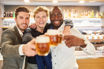Three friends drink beer together and celebrate
