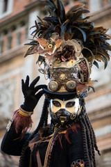 Participant of Venetian carnival in beautiful fantasy hat. Mad Hatter concept