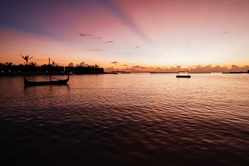 Beautiful sunset at a resort in the Maldives, with boat and swimming equipment in the water