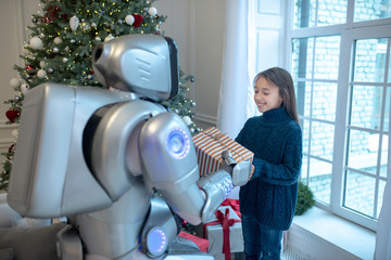 Pretty girl getting a christmas gift from her robot friend