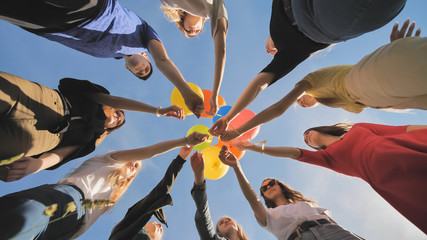 A group of friends release colorful balloons into the sky.