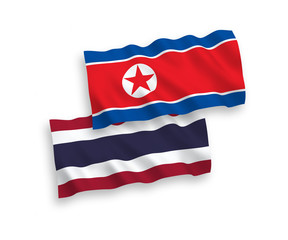 National vector fabric wave flags of North Korea and Thailand isolated on white background. 1 to 2 proportion.