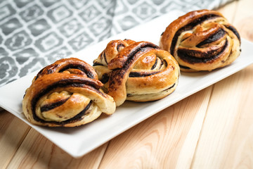 Homemade buns with dark chocolate on a  light rustic  background copy space.