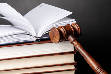 Wooden gavel and juridical books close up