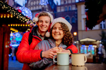 Young couple with drinks on Christmas market in Wroclaw, Poland