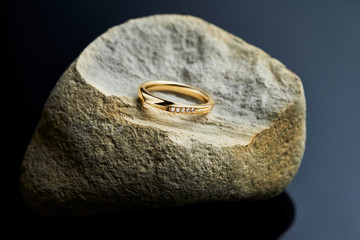 Women’s engagement gold ring with diamonds on the stone, black background