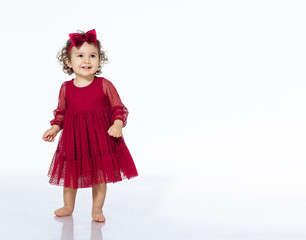 child 2 years old girl in a red dress isolate white background dancing smiling pretty beautiful in a bow festive outfit birthday new year christmas