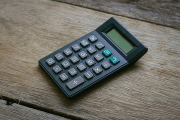 Calculator on wooden background. 